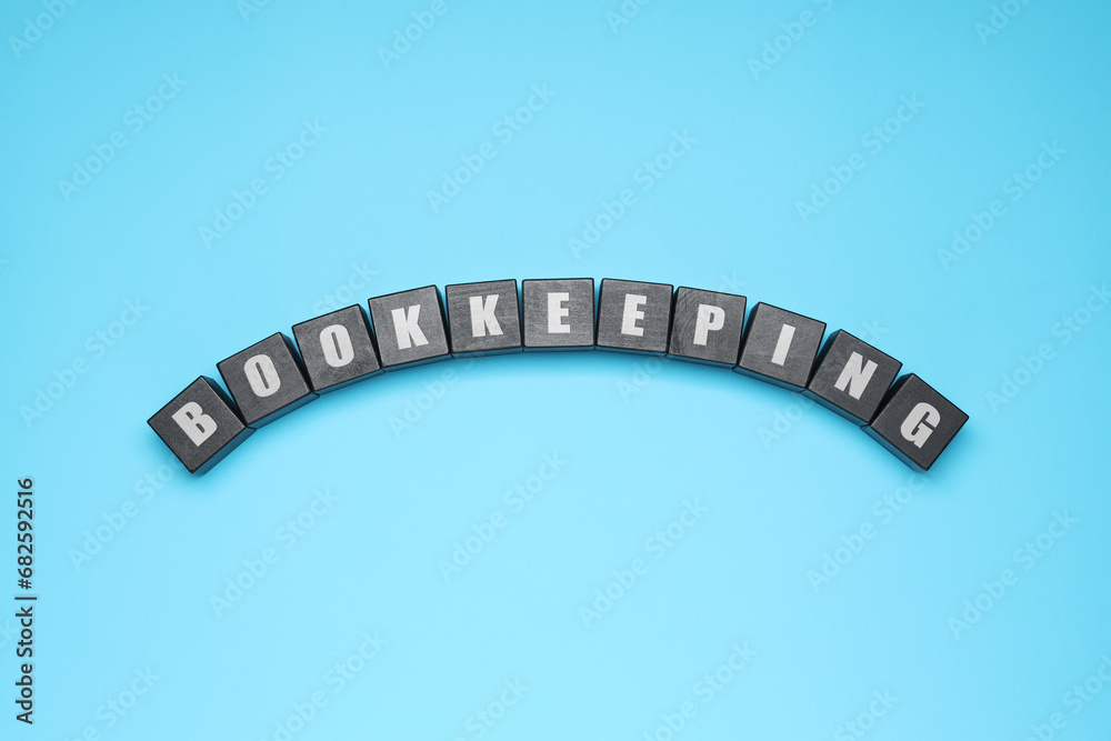 Word Bookkeeping made with black cubes on light blue background, top view Word Bookkeeping made with black cubes on light blue background, top view