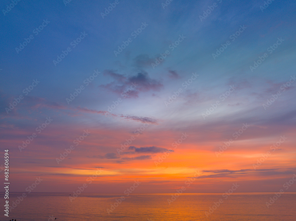 Aerial view colorful reflection of stunning sunset..beautiful scene with the sun painting the sky above waves .breaking gently on a sandy.Gradient sweet color. abstract nature background.