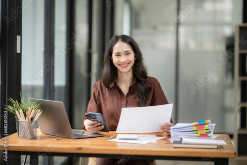 Asia businesswoman working on digital tablet executives meeting in an office using laptop... © aekachai