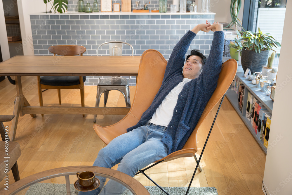 Fototapeta premium 部屋で伸びをしてリラックスする男性 全身