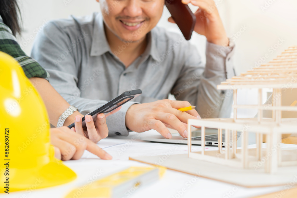 Business people working together on a building project, desktop side view with tools Business people working together on a building project, desktop side view with tools