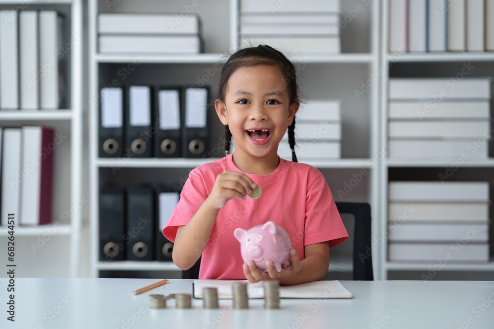 Cute little Asian girl playing with coins, making money in piles, putting money in a piggy bank. Count your saved coins and learn about frugality. Educational planning, management, future concepts. Cute little Asian girl playing with coins, making money in piles, putting money in a piggy bank. Count your saved coins and learn about frugality. Educational planning, management, future concepts.