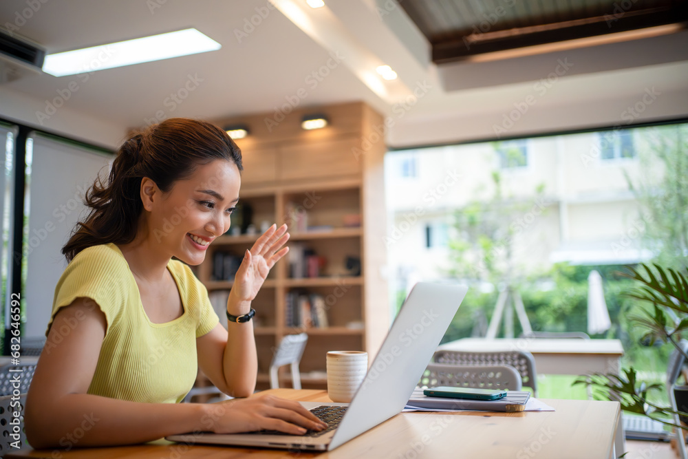 Young woman having video call via computer in the home office.Business video conferencing. Young woman having video call via computer in the home office.Business video conferencing.