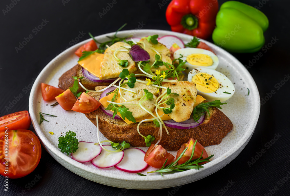 toast with chicken breast, onion and vegetables on a white plate close up toast with chicken breast, onion and vegetables on a white plate close up