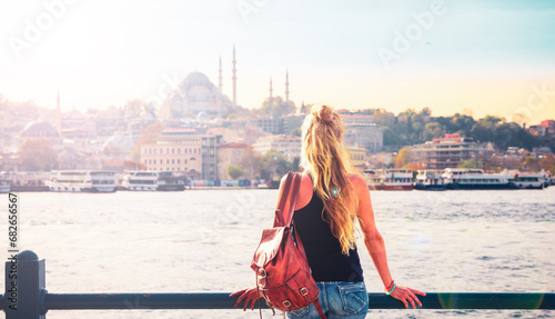 Young female tourist looking at Istanbul city panorama view at sunset- Travel, vacation or tour tourism in Turkey photo