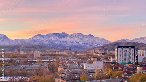 Amazing dawn view from the window of the slightly snowy Kyrgyz mountains. Ala Archa National Reserve, view from afar. Autumn in the capital of Kyrgyzstan - Bishkek. photo