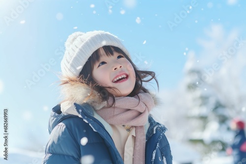 冬の青空の下で雪遊びをする日本人の子供（雪景色・ 笑顔・家族）