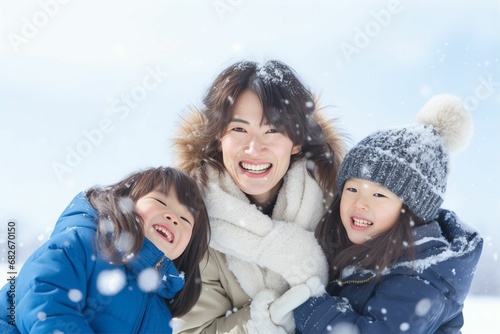 冬の青空の下で雪遊びをする日本人の親子（雪景色・ 笑顔・家族）