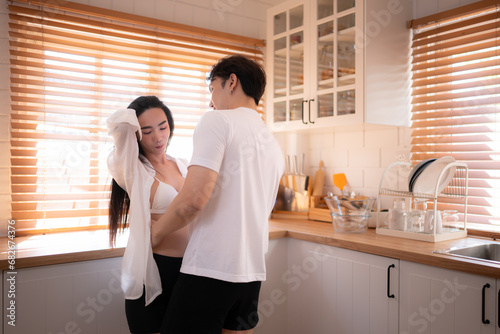 Young asian couple have fun dancing together in the kitchen at home. Happy family concept.
