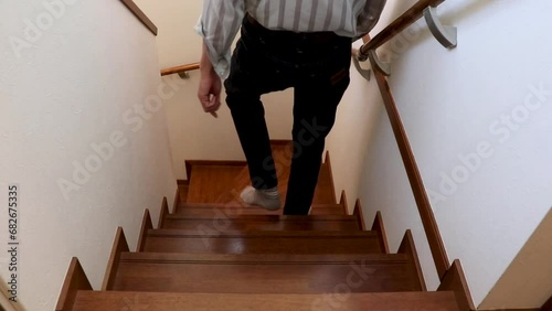 木の階段を下りる男性