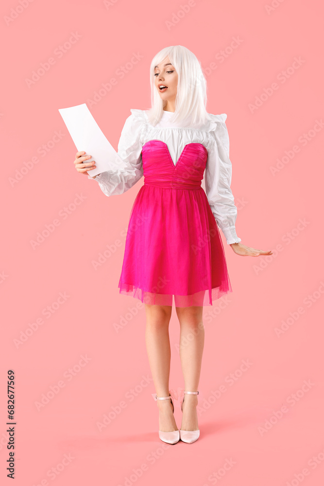 Beautiful actress in wig with film script on pink background Beautiful actress in wig with film script on pink background