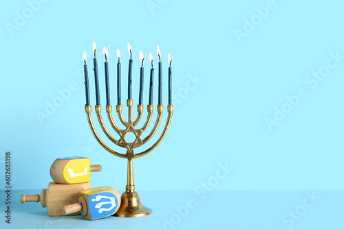 Menorah with dreidels on blue background. Hanukkah celebration photo