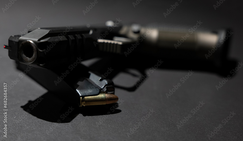 Obraz premium Modern Elegant Handgun and Bullet on Grey Background in Switzerland.