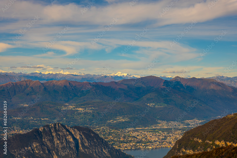 Aerial View over Beautiful Mountainscape with Snow Capped Mountain and Lake Lugano and City of Lugano in a Sunny Day in Ticino, Switzerland.