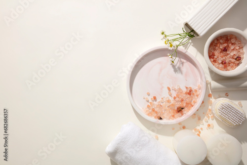 Pink salt and props are displayed against a minimalist background. Free space for product display and advertising. Take care for body with products with natural ingredients.