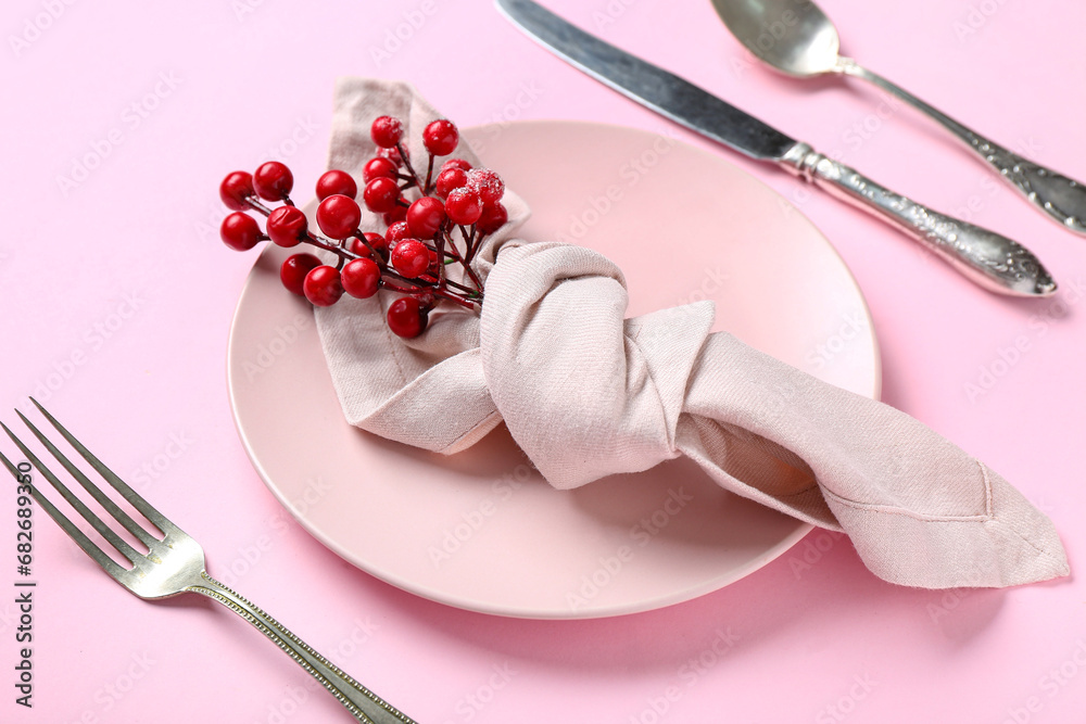 Beautiful Christmas table setting with rowan on pink background Beautiful Christmas table setting with rowan on pink background
