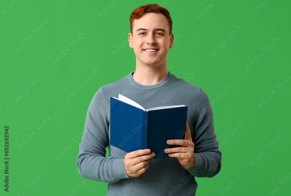 Smiling handsome man with book on green background Smiling handsome man with book on green background