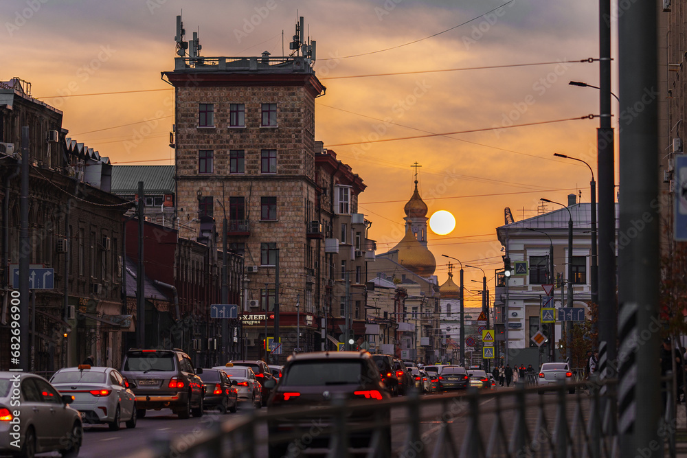 Urban evening landscape. The setting sun over the city road. 