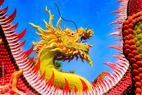 Yellow dragon statue with blue sky photo