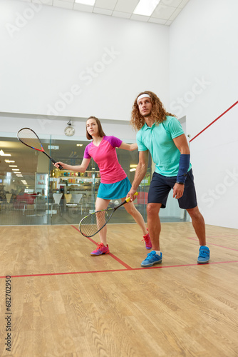 People playing squash enjoying recreational pursuit at indoor training club