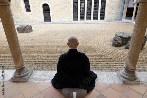 Zen buddhist monk practising zazen (meditation) in Orval trappist abbey's zen garden, Belgium. photo