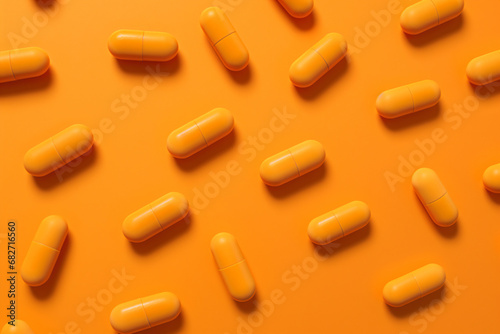 Orange capsule pills scattered on an orange background. - Generative AI