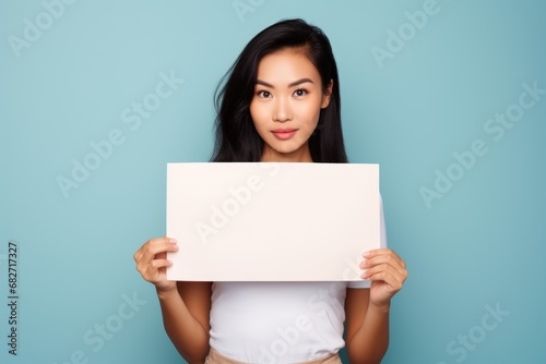 smiling woman holding a blank placard sign poster paper in his hands photo