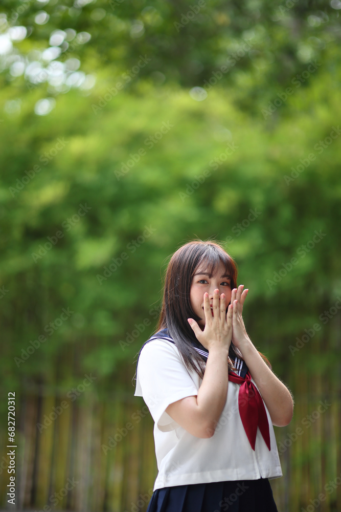 Japanese high school student with happy and pointing on copy space in bamboo background Japanese high school student with happy and pointing on copy space in bamboo background