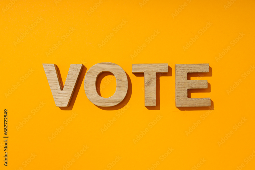 Wooden letters on yellow background, top view Wooden letters on yellow background, top view
