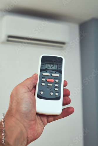 Man holding a modern AC unit remote.