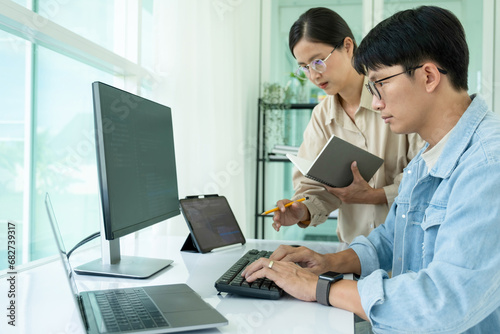 IT programmers working together at office desk.