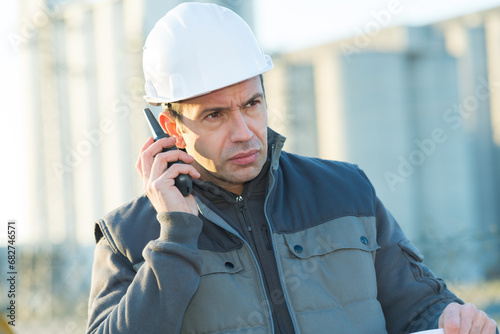 man in jacket and helmet talking on the phone outdoors
