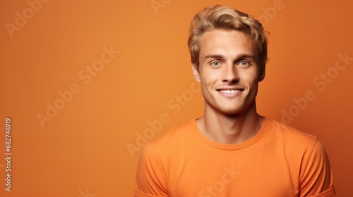Young cheerfull blond european man he wearing basic orange t-shirt. Looking camera isolated on plain orange color background studio photo