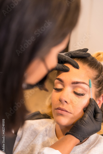 Hairdresser combing the eyebrows of a client