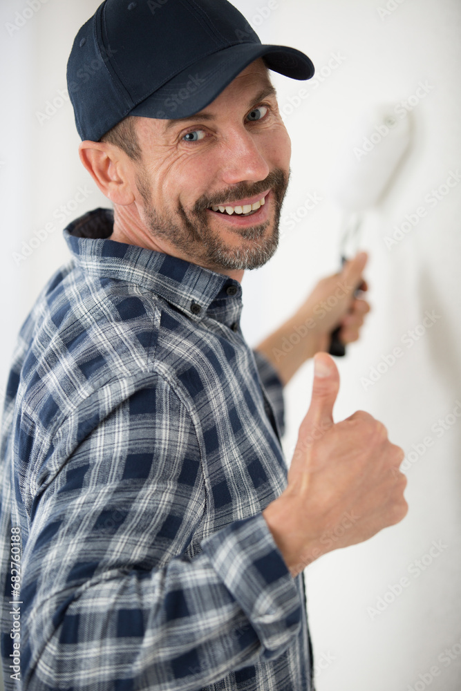 cheerful painter decorator giving thumbs up cheerful painter decorator giving thumbs up