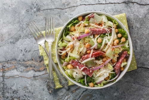 La Scala Chopped Salad with simple ingredients like chopped romaine, salami, and mozzarella close-up in a bowl. Horizontal top view photo