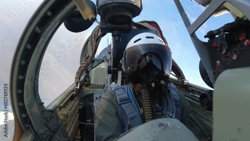 A pilot in a helmet inside the cockpit of a fighter