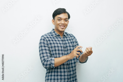 Portrait Asian Indonesian young man spraying perfume to his body photo