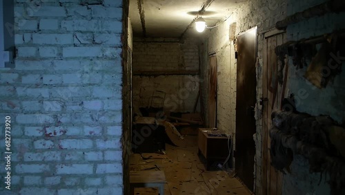 war in Ukraine
a bomb shelter in a civilian residential building
the gloomy atmosphere of people's lives during rocket attacks
a dingy basement hallway with minimal lighting and seating photo