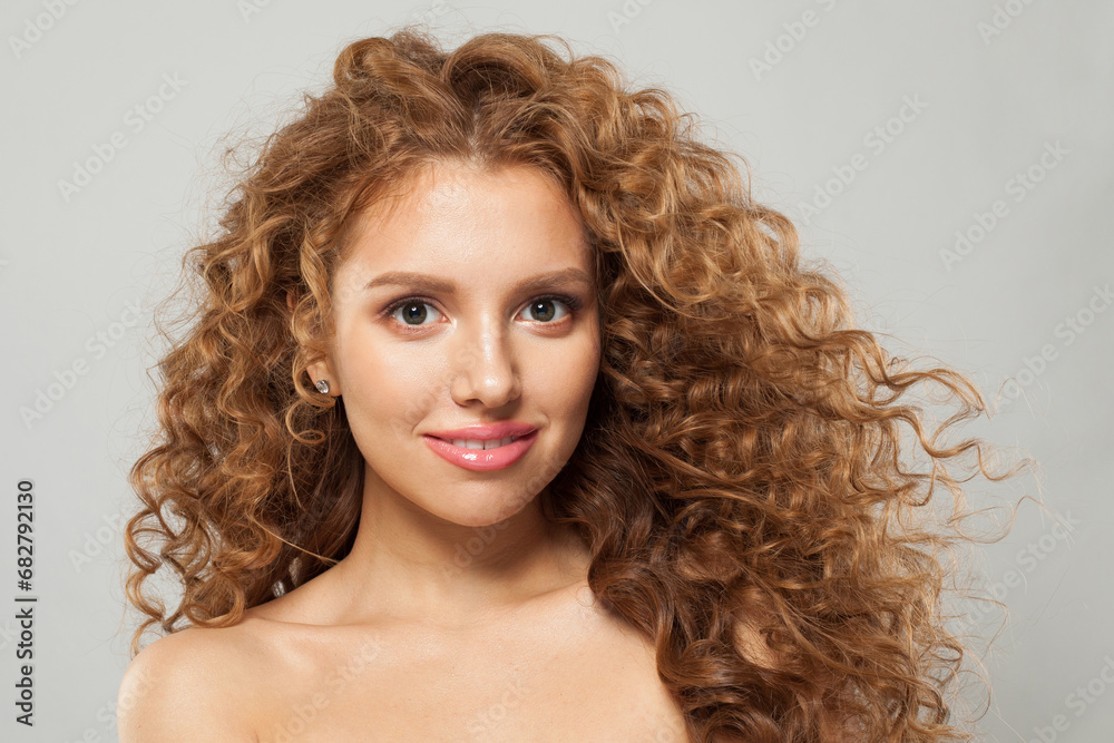 Redhead woman fashion model with long wavy hairstyle, natural makeup and clear skin. Haircare, facial treatment and skincare concept