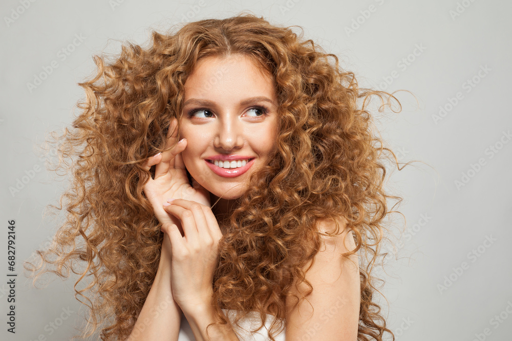 Beautiful young fashion model woman with natural makeup, clear skin and curly hairstyleposing on white background