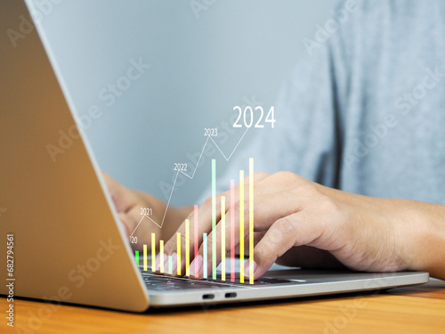 Financial market data analysis, business and investment in 2024, strategic planning on laptop Businessman who predicts higher profit returns on marketing investments.