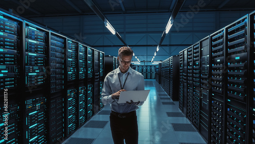 Futuristic Concept: Big Data Center Chief Technology Officer Holding Laptop, Standing In Warehouse, Information Digitalization Lines Streaming Through Servers. SAAS, Cloud Computing, Web Service