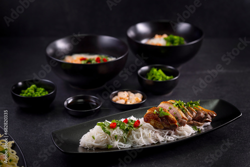 Various dishes of Asian cuisine with different types noodles and rice with shrimp, duck, vegetables and black sesame