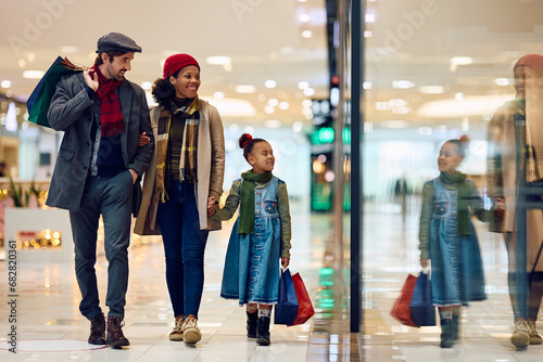 Happy multiracial family enjoys in Christmas shopping at mall.