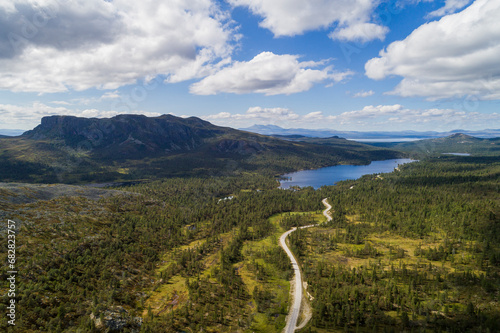 Aerial high angle view of river and road running through forest and mountainous landscape in northern Sweden photo