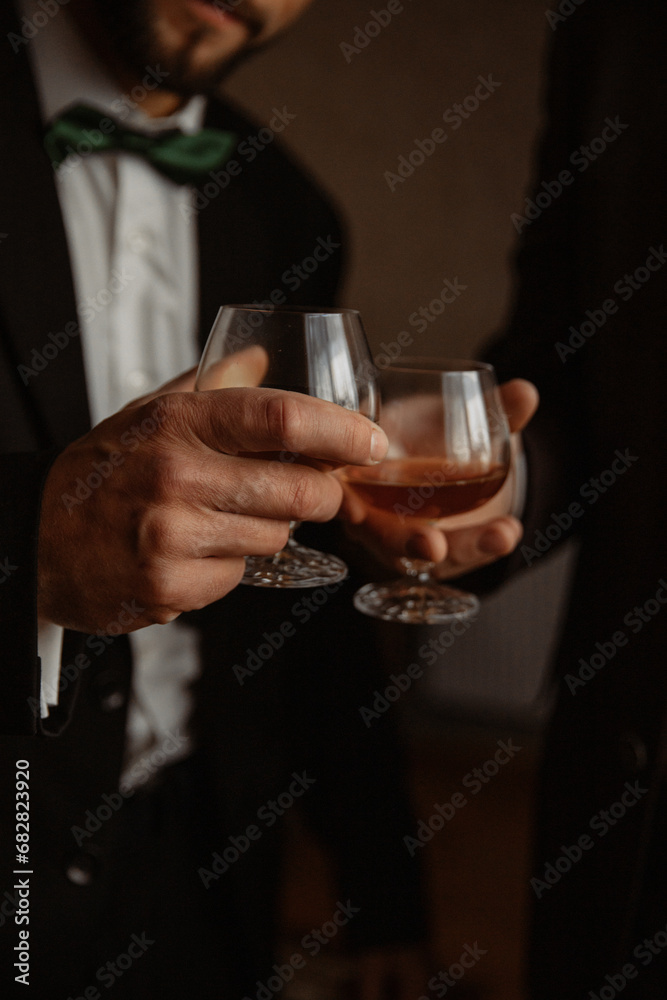 Close up of two glass goblets with alcohol resting on a wooden table Close up of two glass goblets with alcohol resting on a wooden table