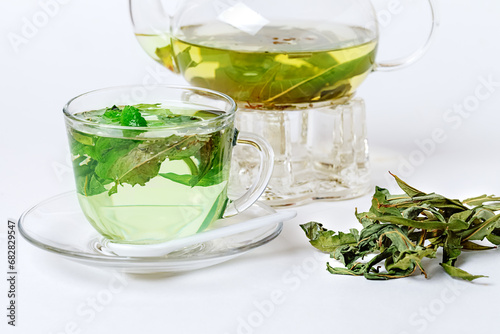 Herbal organic Chamaenerion tea in glasspot and teacup isolated on white background. Side View. Close up.