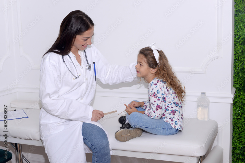 Pediatrician examining little child patient’s throat at clinic Pediatrician examining little child patient’s throat at clinic
