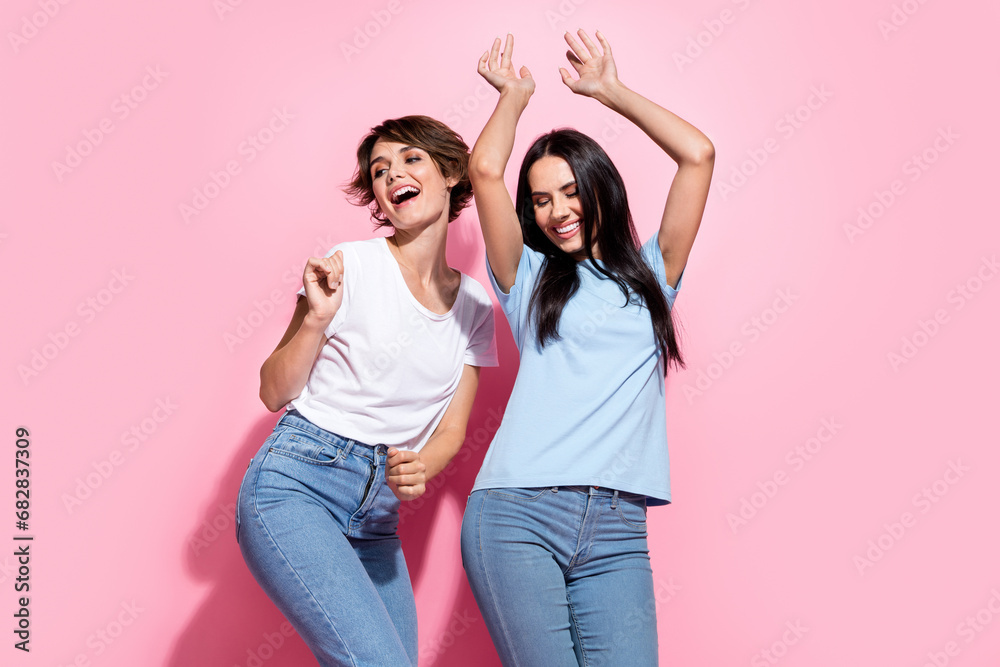 Obraz premium Two young girls dancing photo portrait of best friends chill hands up relaxing celebrate sale season ad isolated on pink color background